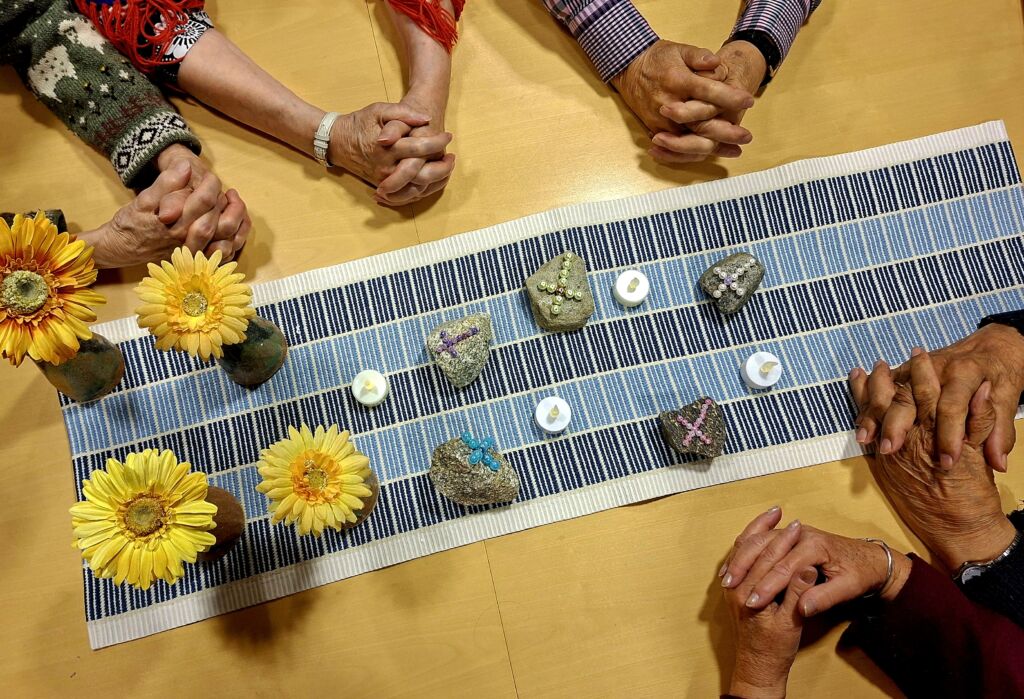 Kädet ristissä pöydän ympärillä